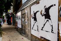 FILE - Posters of a person throwing a sandwich are pictured along H Street, Aug. 17, 2025, in W ...