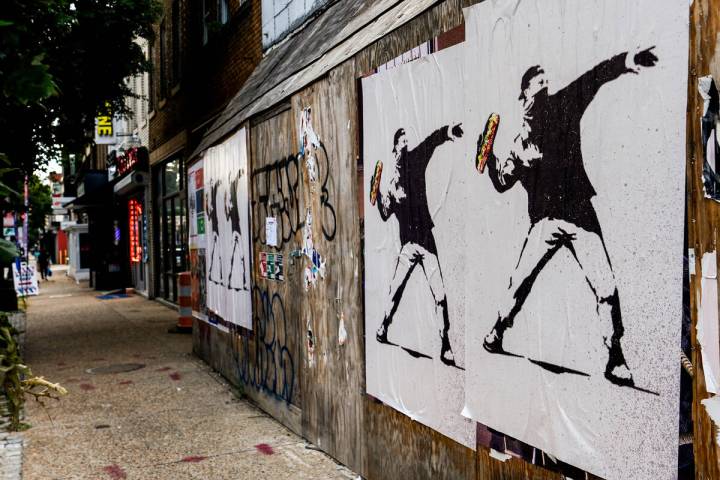 FILE - Posters of a person throwing a sandwich are pictured along H Street, Aug. 17, 2025, in W ...