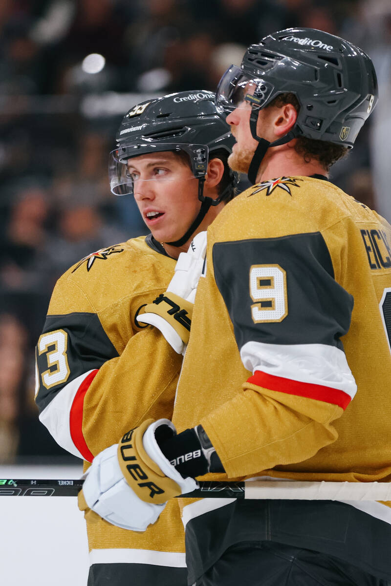 Golden Knights teammates Mitch Marner (93) and Jack Eichel (9) confer before a puck drop in the ...