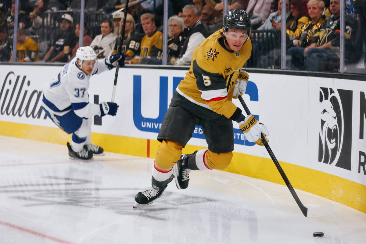 Golden Knights defenseman Kaedan Korczak (6) tries to keep the puck away from Tampa Bay Lightni ...
