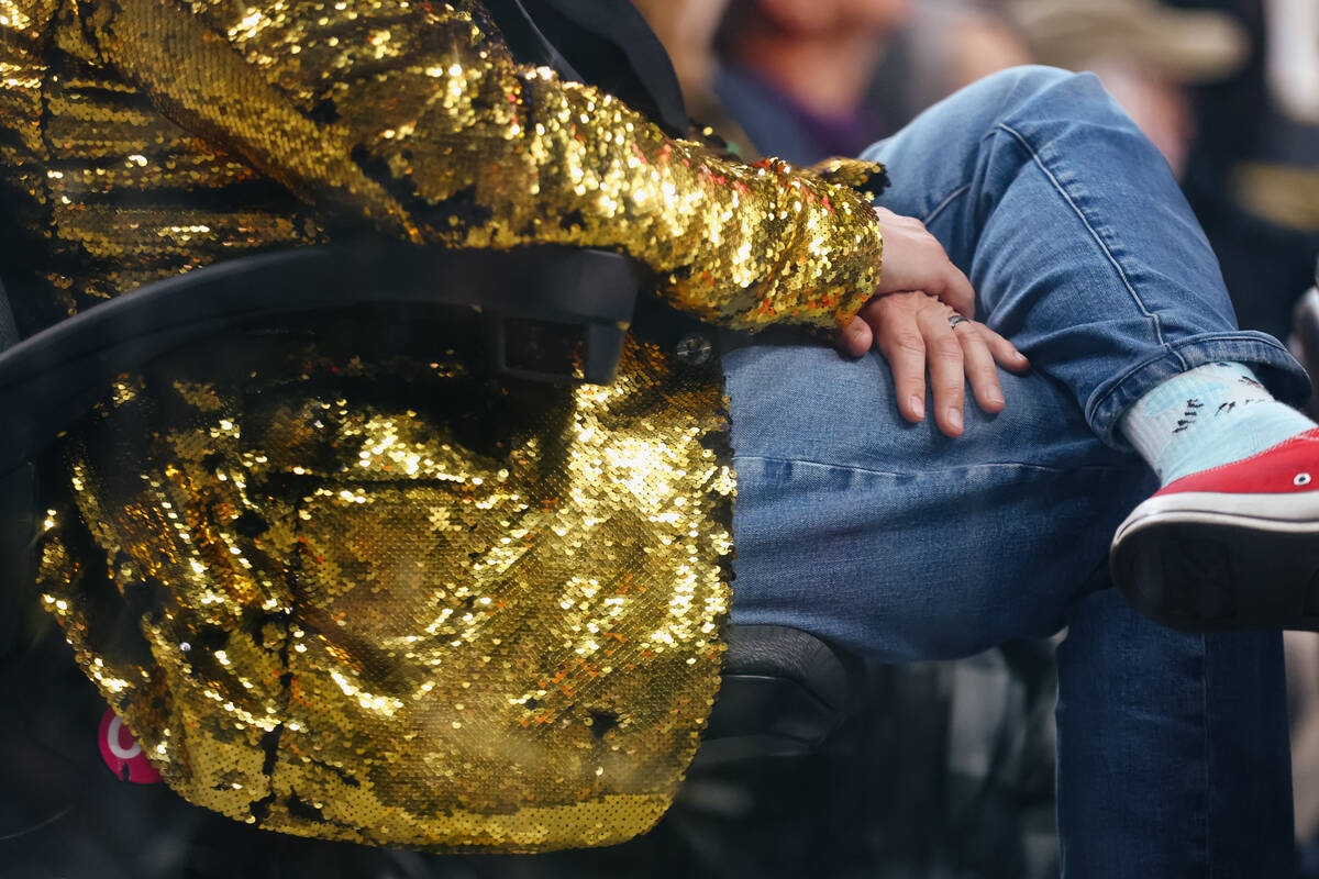 A fan wears a glittering golden jacket while watching the third period of the game on Thursday, ...