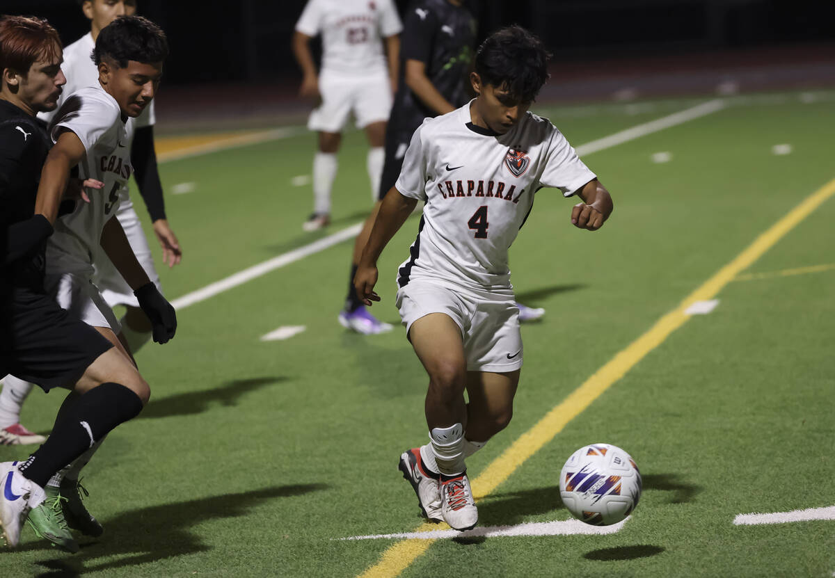Chaparral's Esteban Javier Romero (4) runs with the ball under pressure from SLAM! Nevada ...