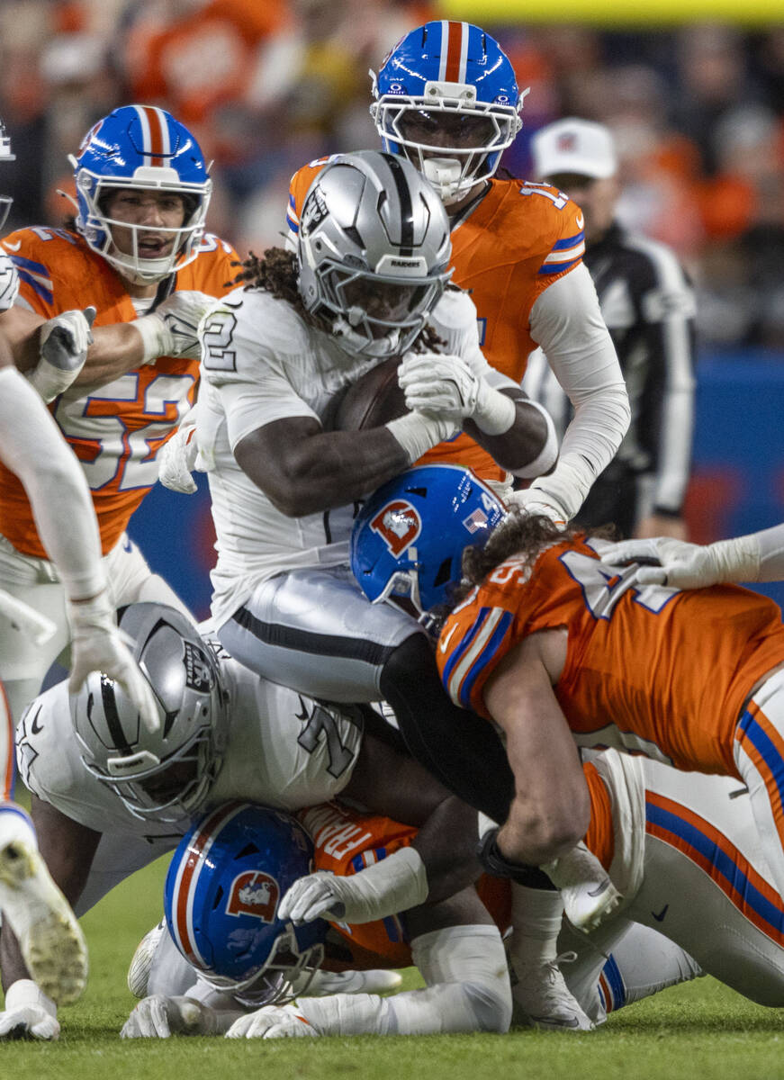 Raiders running back Ashton Jeanty (2) is tackled by Denver Broncos linebacker Alex Singleton ( ...