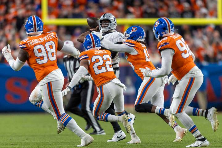 Raiders quarterback Geno Smith (7) is swarmed by Denver Broncos defenders during the second hal ...