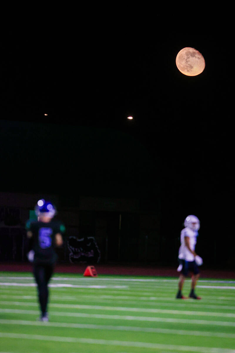 Players walk on the field under the moon during a class 5A high school football southern region ...