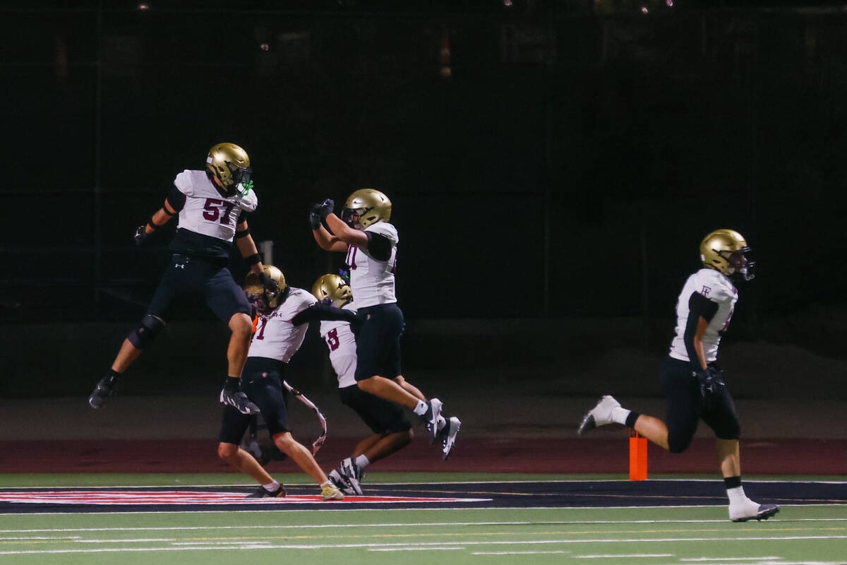 Faith Lutheran celebrates an interception that turned into the Crusaders’ first touchdow ...