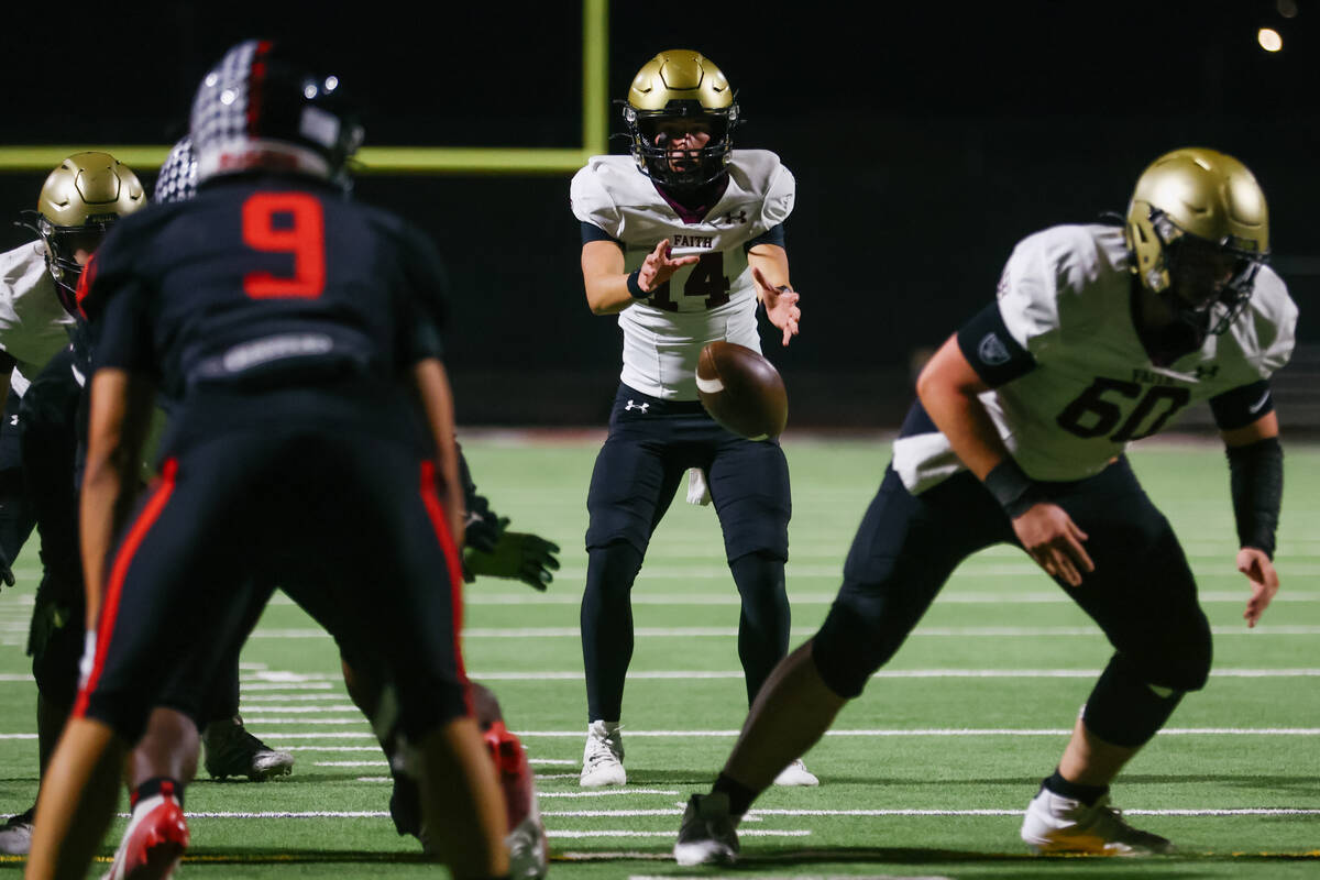 Faith Lutheran quarterback Dominick Folino (14) catches the snap during the Southern Region sem ...