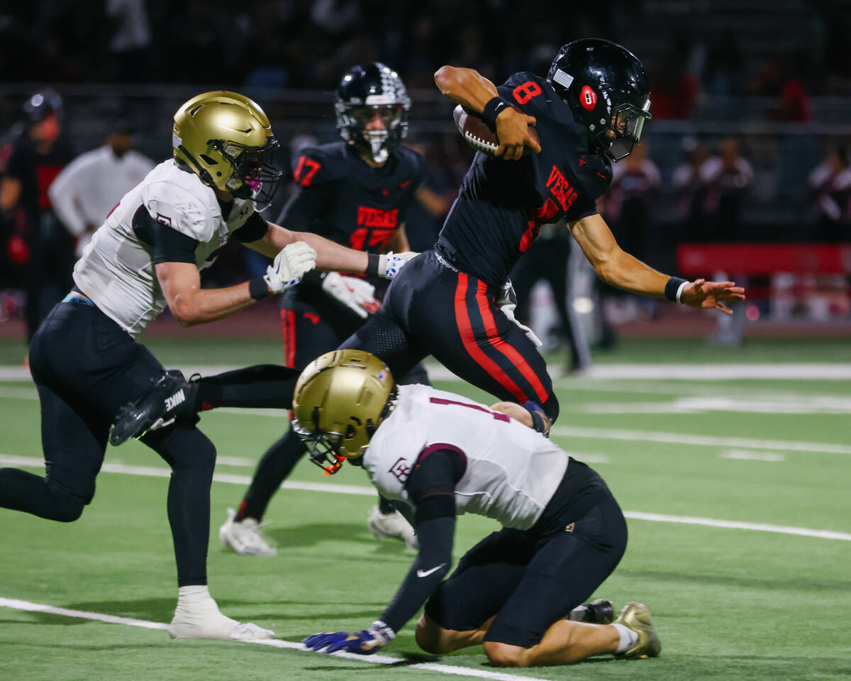 Las Vegas quarterback Tanner Vibabul (8) leaps over Faith Lutheran defensive back Gavin Day (1) ...