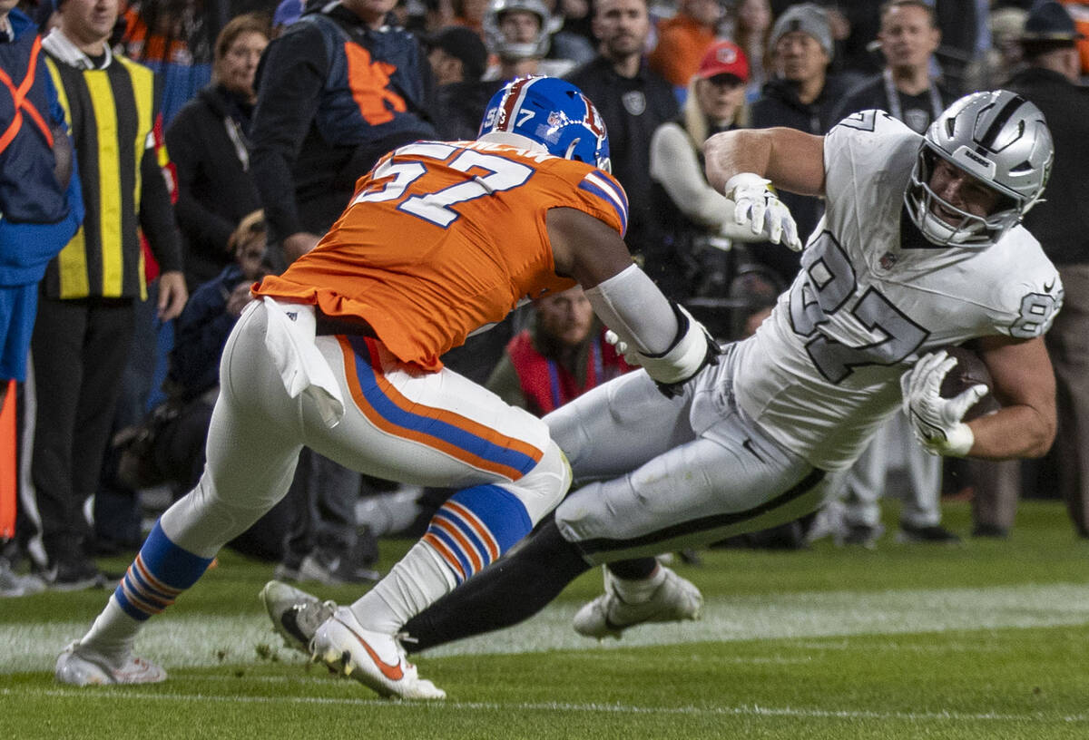 Raiders tight end Michael Mayer (87) makes a catch with Denver Broncos linebacker Dre Greenlaw ...