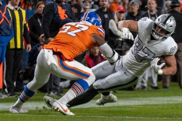 Raiders tight end Michael Mayer (87) makes a catch with Denver Broncos linebacker Dre Greenlaw ...