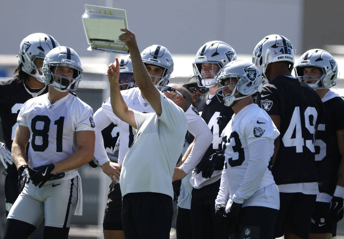 Raiders special teams coordinator Tom McMahon discusses practice drills with his players during ...