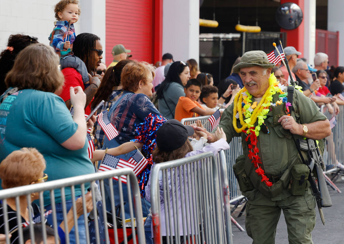 Robert Davison, who served in the U.S. Army during the Vietnam War, shakes hands with paradegoe ...