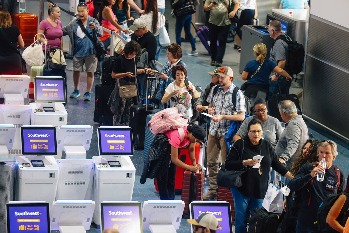 People wait in line at the Southwest ticket desk at Harry Reid International Airport Sunday, No ...