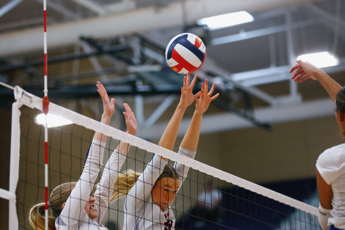 Coronado setter Tru Halvorsen (6) and middle blocker Rachel Purser (9) reach up to attempt a bl ...