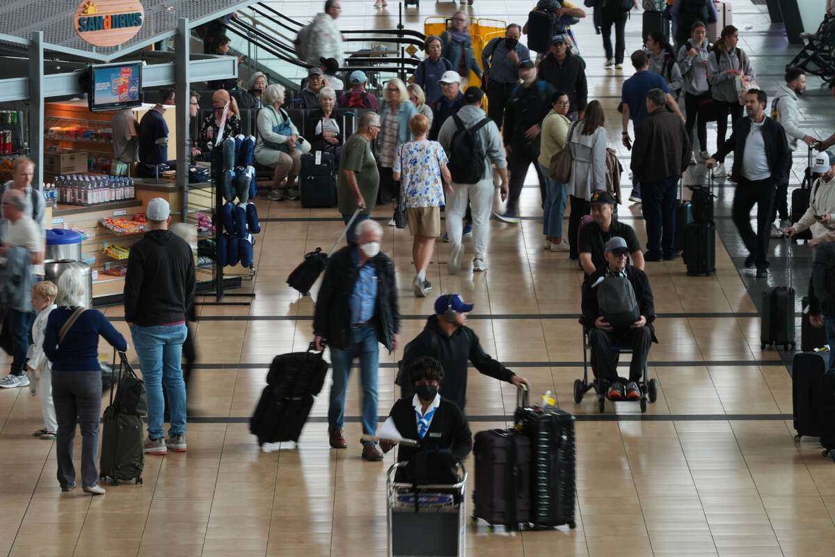 People make their way through a terminal at San Diego International Airport Saturday, Nov. 8, 2 ...