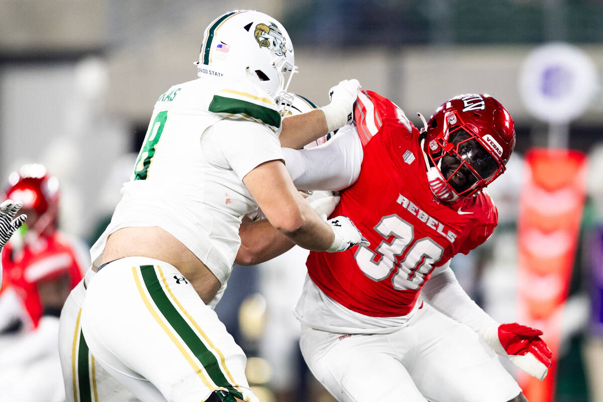 Colorado State Rams offensive lineman Aaron Karas (78) holds UNLV defensive end Tunmise Adeleye ...