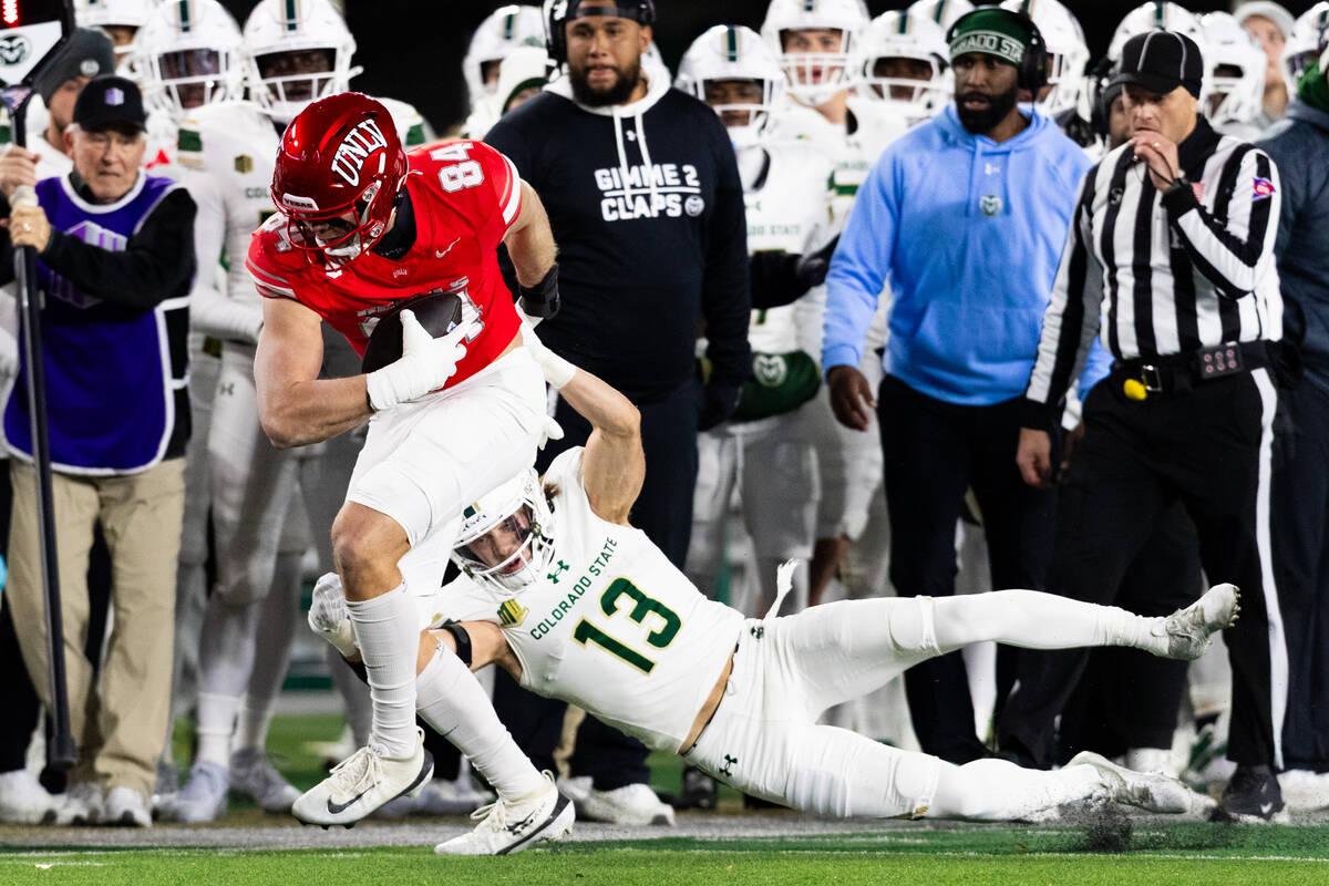 UNLV tight end Nick Elksnis (84) attempts to outrun Colorado State Rams ldefensive back Jake Ja ...