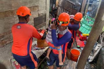 In this photo provided by the Philippine Coast Guard, rescuers evacuate residents to safer grou ...