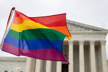 Supporters of the LGBT wave their flag in front of the U.S. Supreme Cour, Oct. 8, 2019, in Wash ...