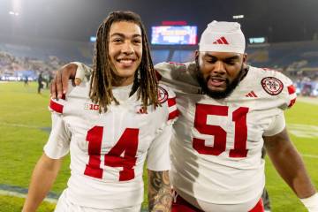 Nebraska quarterback TJ Lateef (14) and Nebraska offensive lineman Justin Evans (51) embrace af ...