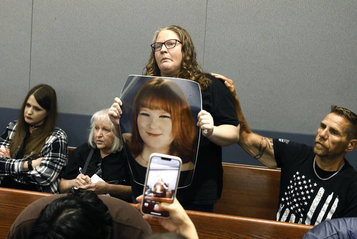 Tiffany Reynolds holds a photograph of her daughter McKenzie Scott during a hearing for Keenan ...