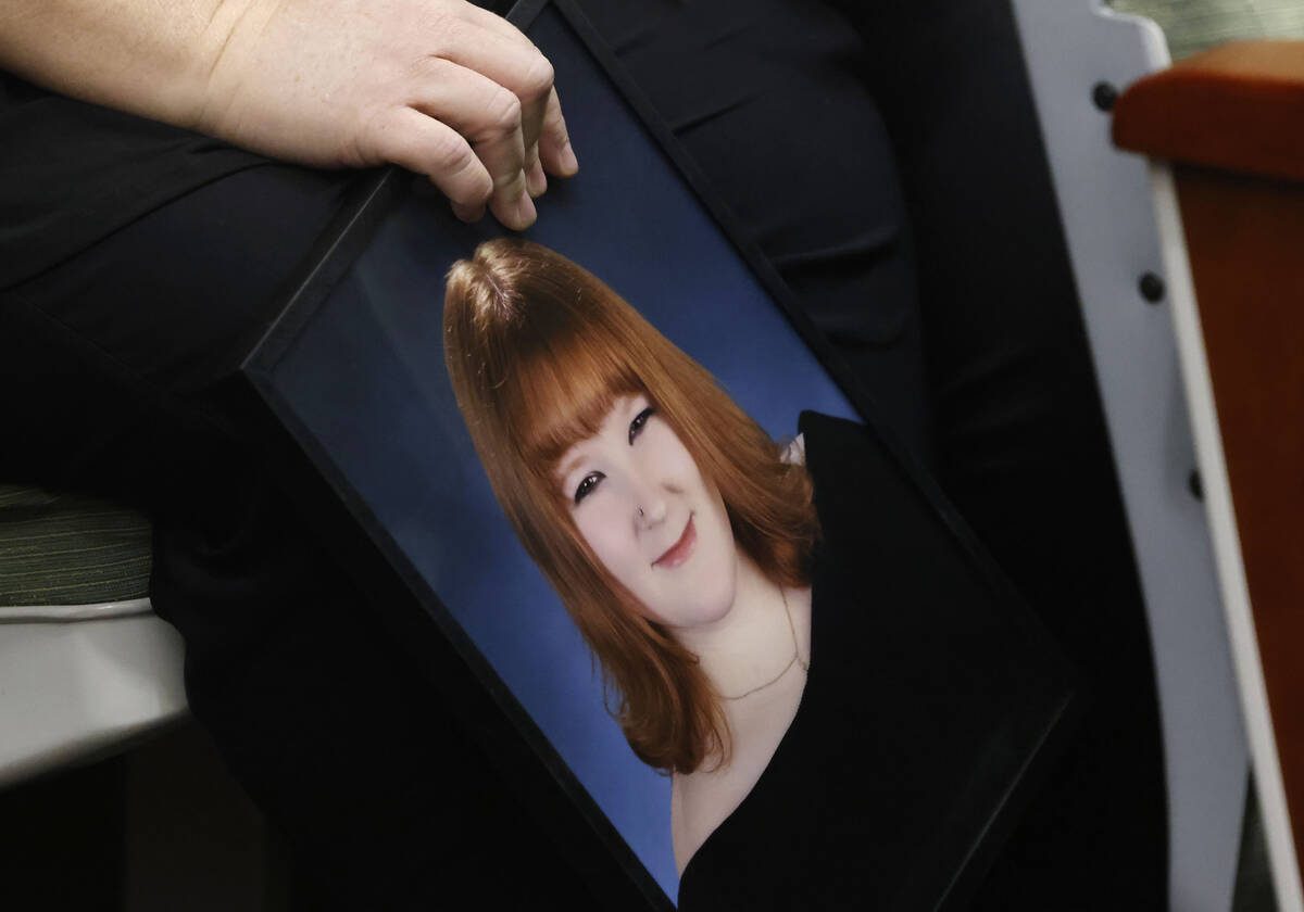 Tiffany Reynolds, holding a photograph of her daughter McKenzie Scott, attends a hearing for Ke ...