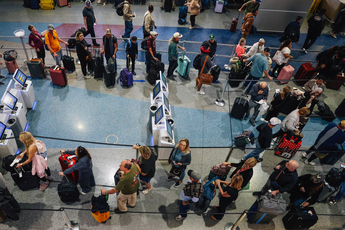 People wait in line at the Southwest ticket desk at Harry Reid International Airport Sunday, No ...