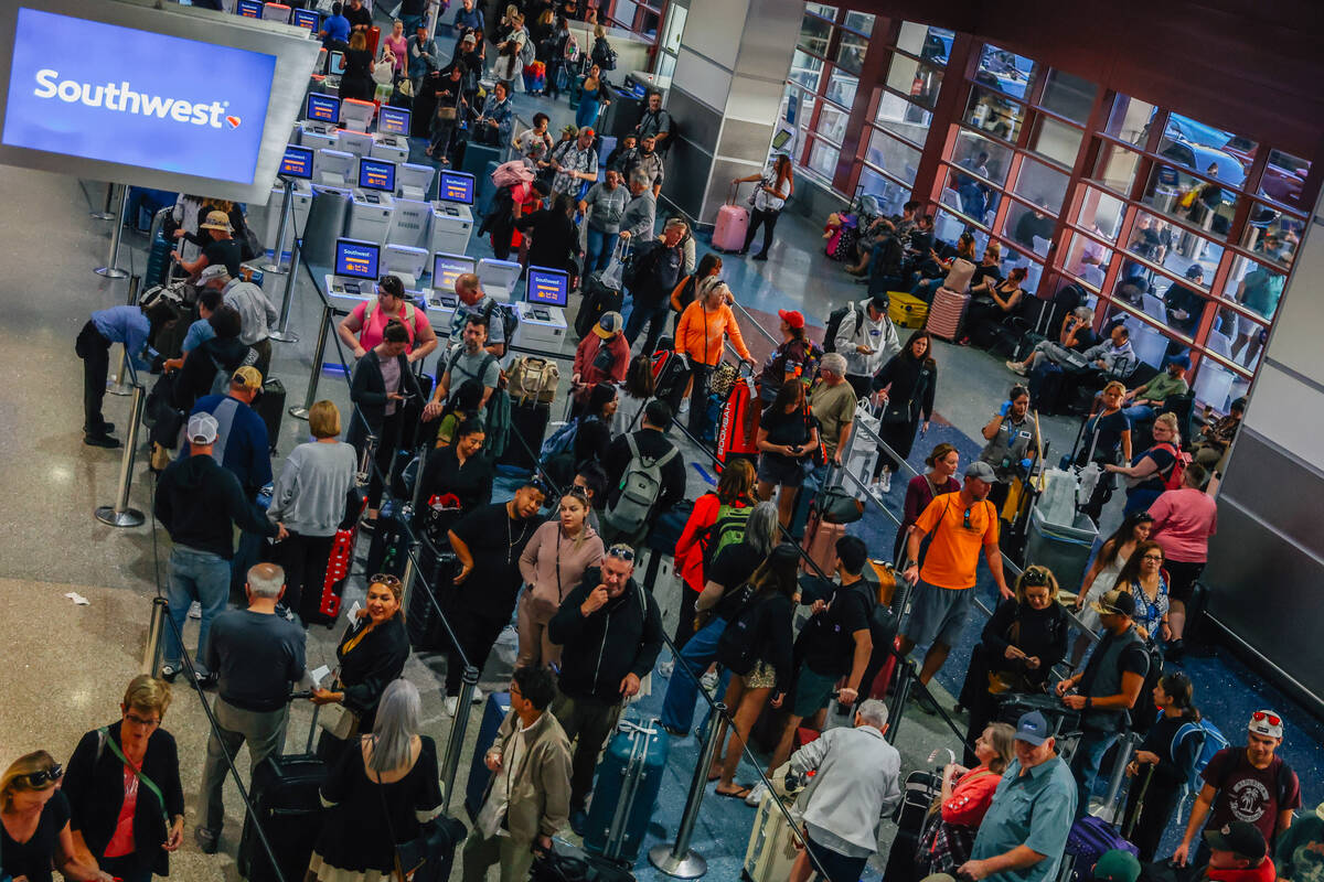People wait in line at the Southwest ticket desk at Harry Reid International Airport Sunday, No ...