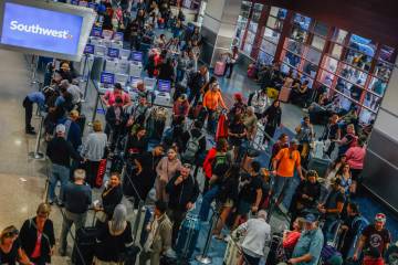People wait in line at the Southwest ticket desk at Harry Reid International Airport Sunday, No ...