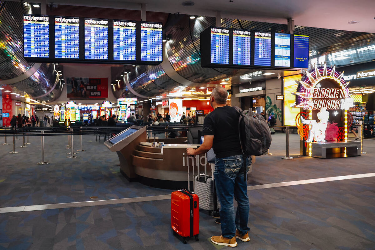 A traveller checks for flight delays at Harry Reid International Airport Sunday, Nov. 9, 2025, ...