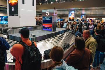 Travelers wait for baggage at Harry Reid International Airport Sunday, Nov. 9, 2025, in Las Veg ...