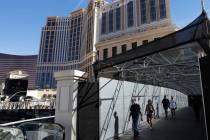 Pedestrians walk on a pedestrian bridge connecting the Palazzo to the Treasure Island hotel-cas ...