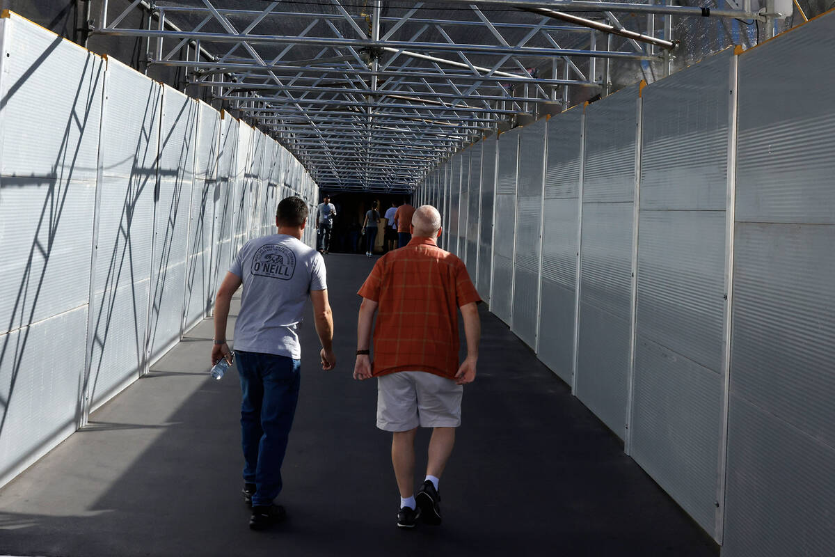 Pedestrians walk on a pedestrian bridge connecting the Palazzo to the Treasure Island hotel-cas ...