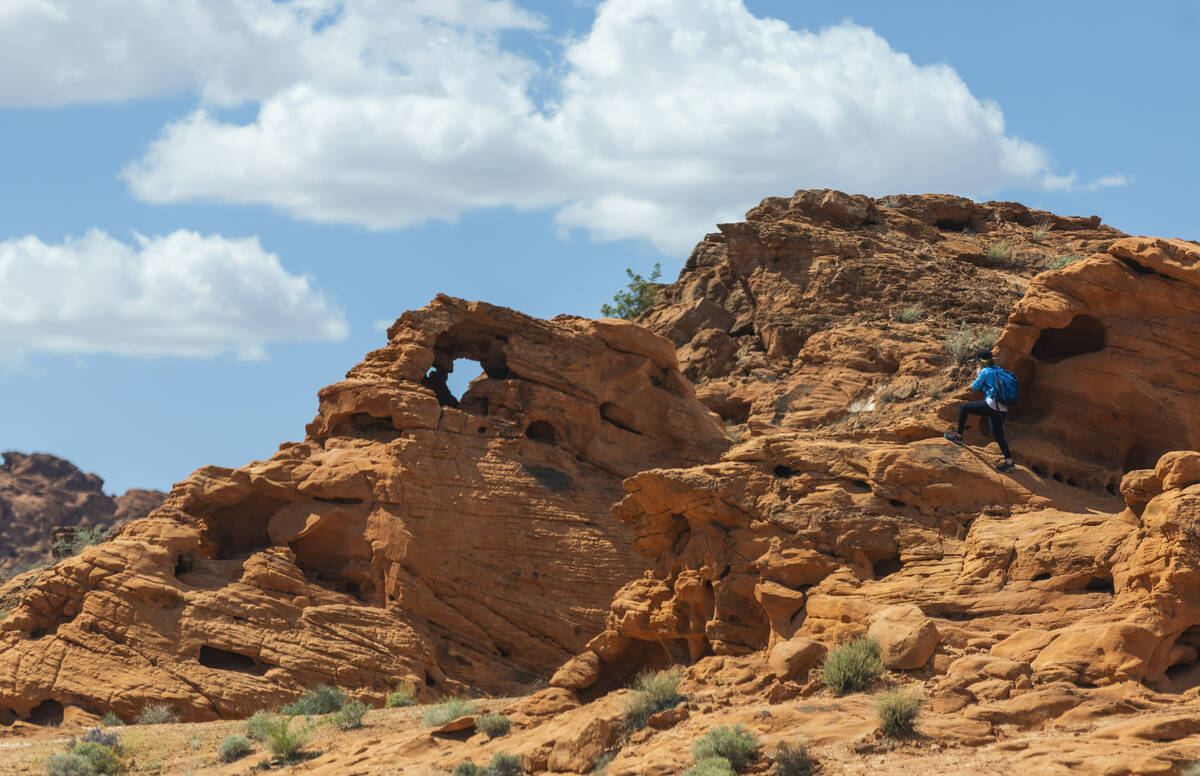 A hiker works their way about the red rock in the Valley of Fire State Park on Thursday, April ...