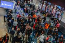 People wait in line at the Southwest ticket desk at Harry Reid International Airport Sunday, No ...