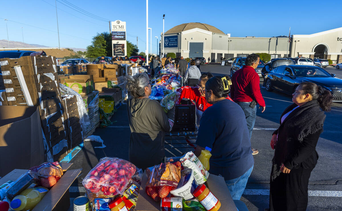 Volunteers pack and distribute food boxes at TCMI Church during the Three Square Food Bank emer ...