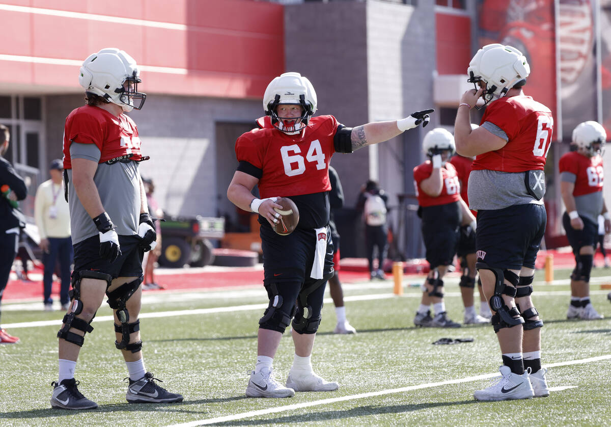 UNLV offensive line Reid Williams (64) gestures as offensive lines Austin Boyd (79) and Toby Mo ...