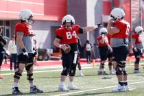UNLV offensive line Reid Williams (64) gestures as offensive lines Austin Boyd (79) and Toby Mo ...