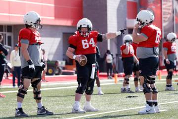 UNLV offensive line Reid Williams (64) gestures as offensive lines Austin Boyd (79) and Toby Mo ...