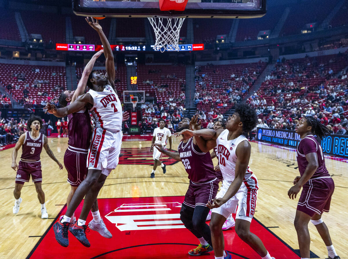 UNLV forward Kimani Hamilton (2) gets a shot off inside of Montana Grizzlies guard Tyler Thomps ...