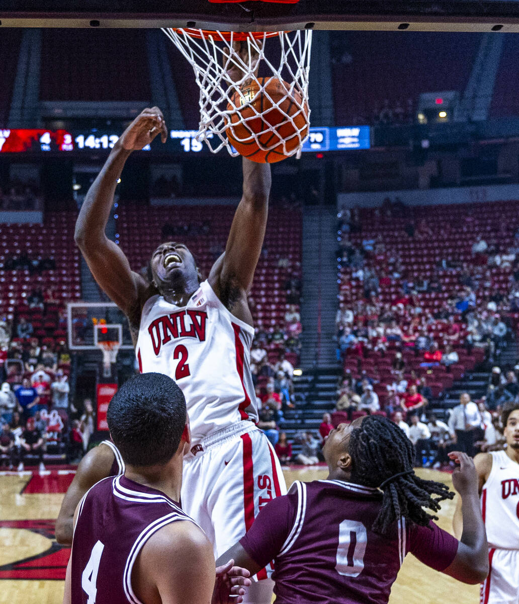UNLV forward Kimani Hamilton (2) diunks the ball as Montana Grizzlies guard Money Williams (0) ...