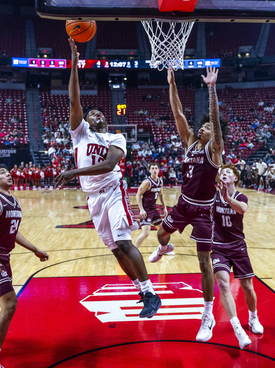 UNLV guard Issac Williamson (12) gets a lay up in past Montana Grizzlies guard Brooklyn Hicks ( ...