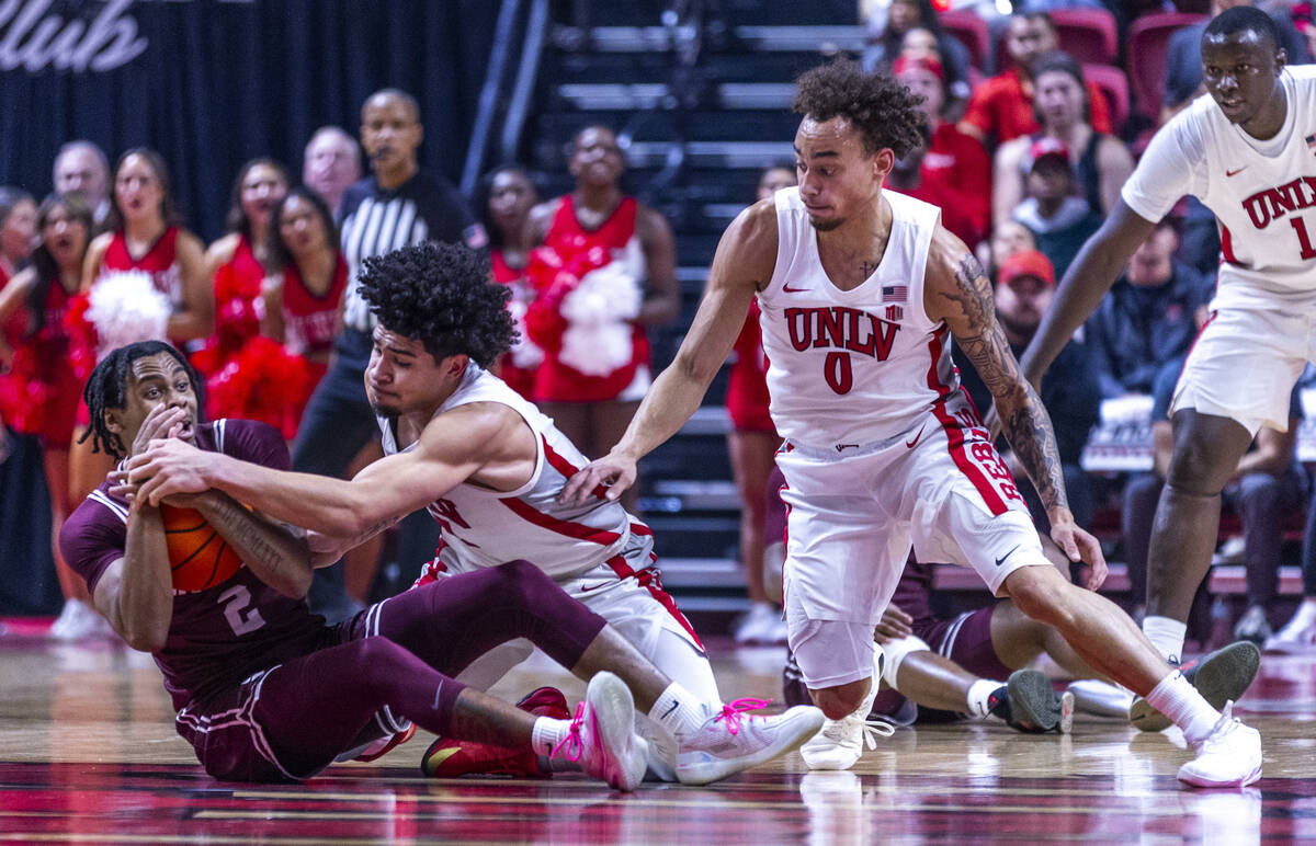 Montana Grizzlies guard Chase Henderson (2) grabs a loose ball as UNLV guard Al Green (7) reach ...
