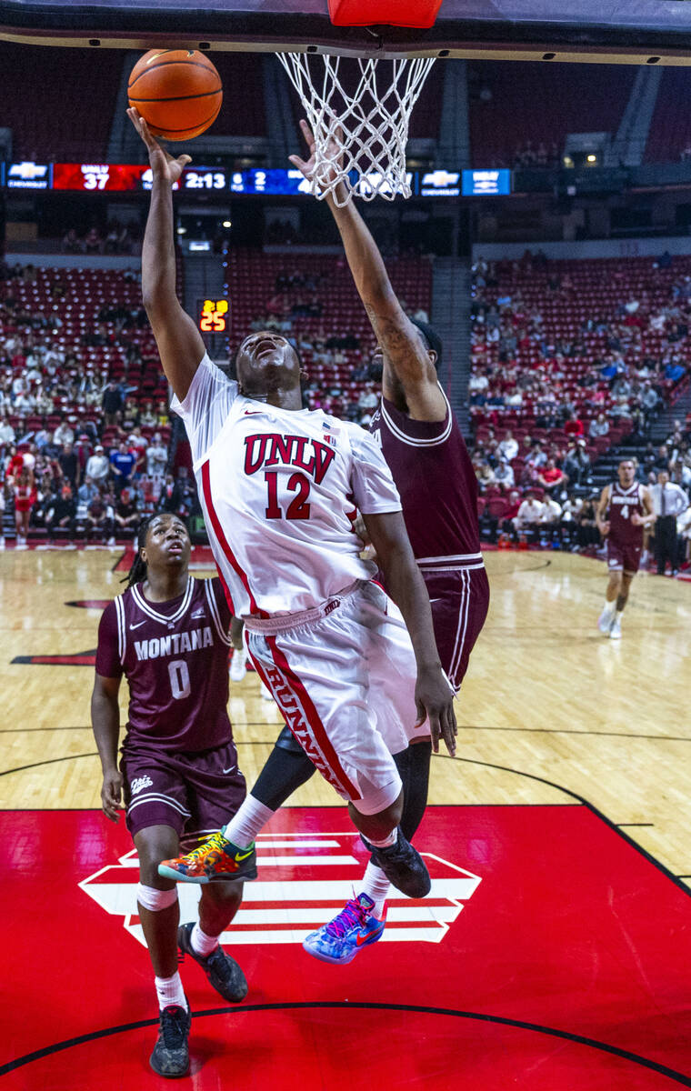 UNLV guard Issac Williamson (12) beats Montana Grizzlies forward Te'Jon Sawyer (32) to the ...