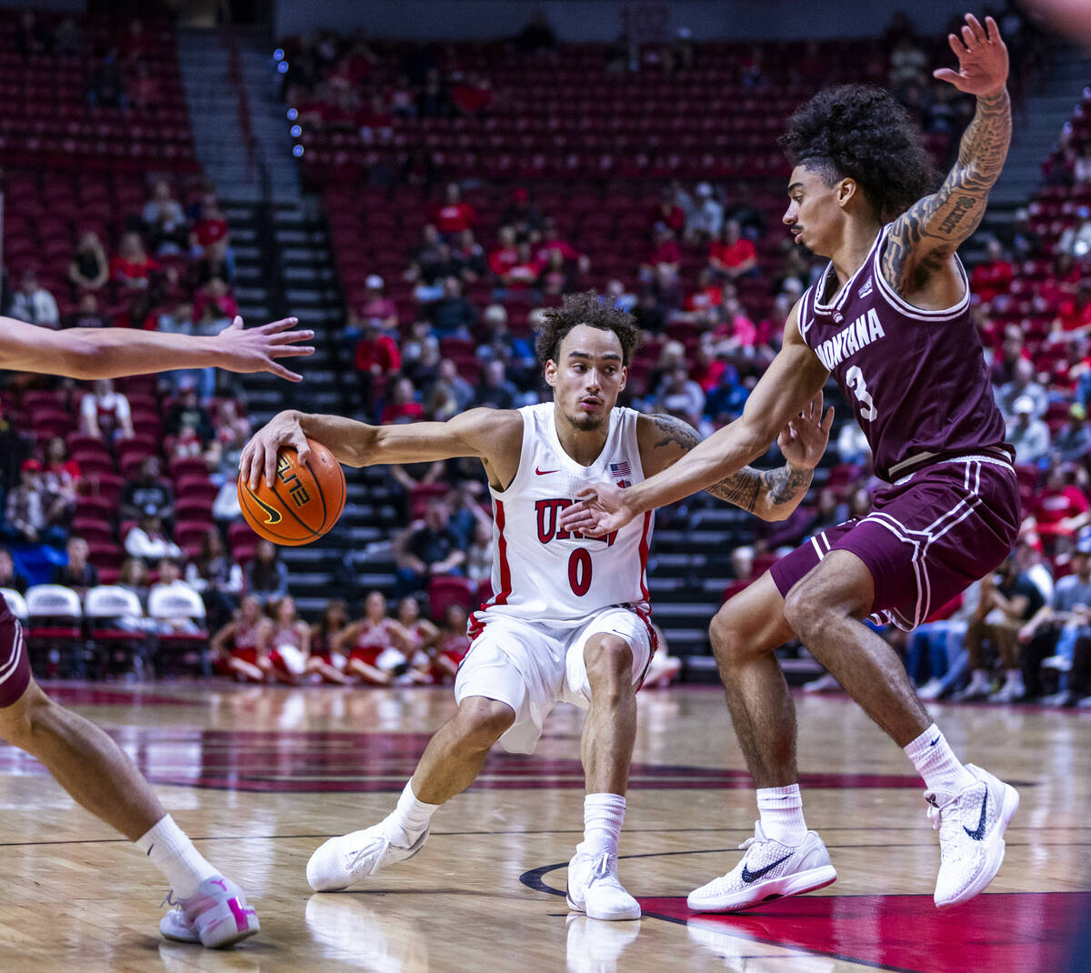 UNLV guard Dra Gibbs-Lawhorn (0) works to get past Montana Grizzlies guard Brooklyn Hicks (3) d ...