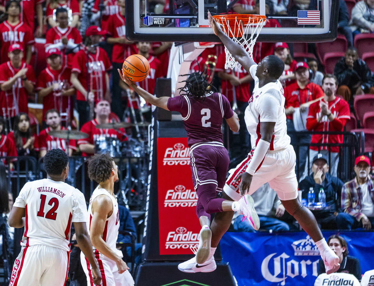 UNLV forward Ladji Dembele (1) gots up high to defend the net from a shot attempt by Montana Gr ...