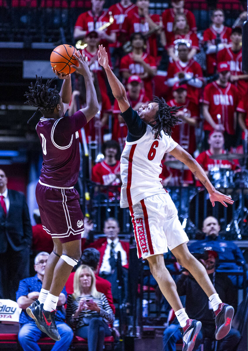 Montana Grizzlies guard Money Williams (0) posts up for a shot attempt as UNLV forward Tyrin Jo ...