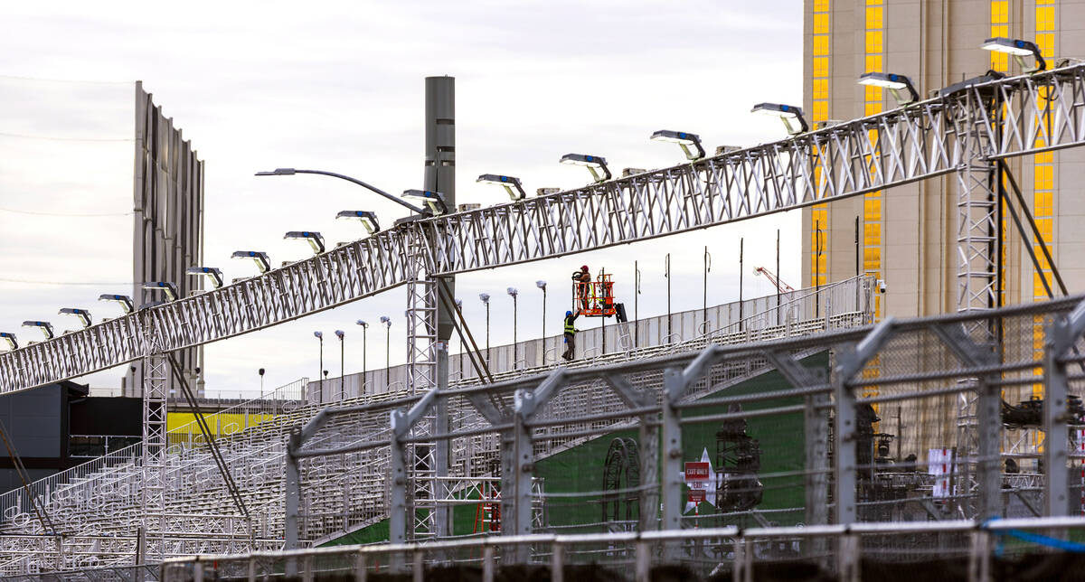 Crewman work with overhead lighting on Harmon Avenue as the final prep is occurring ahead of ra ...