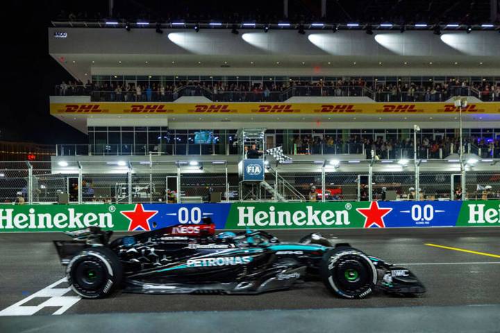 Mercedes driver George Russell crosses the finish line as the flag waves in the tower winning t ...