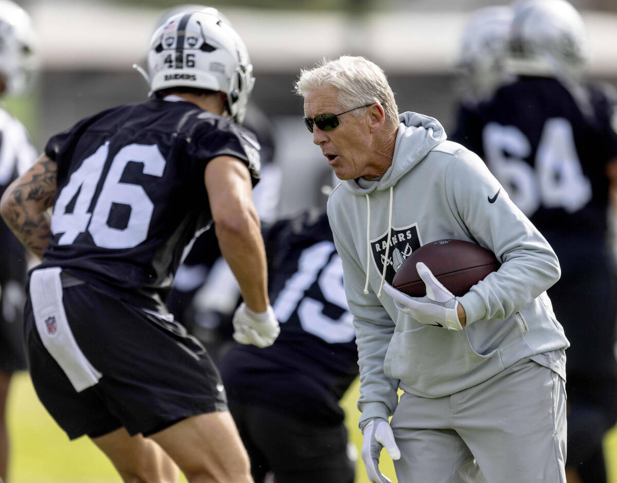 Raiders head coach Pete Carroll works with tight end Carter Runyon (46) during the team’ ...